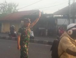 Babinsa Koramil 1605 Sukagumiwang Bantu Anak Sekolah Menyeberangkan Jalan Raya 